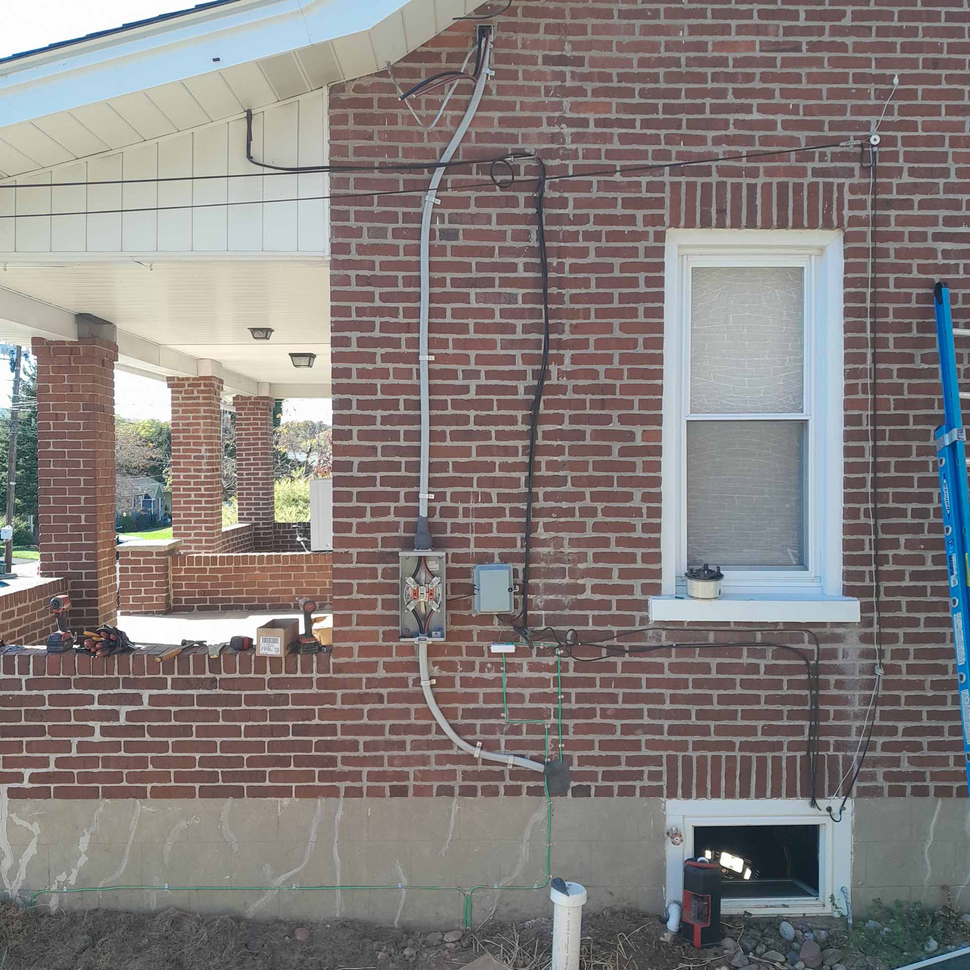 Exterior shot of brick house with electric meter being installed