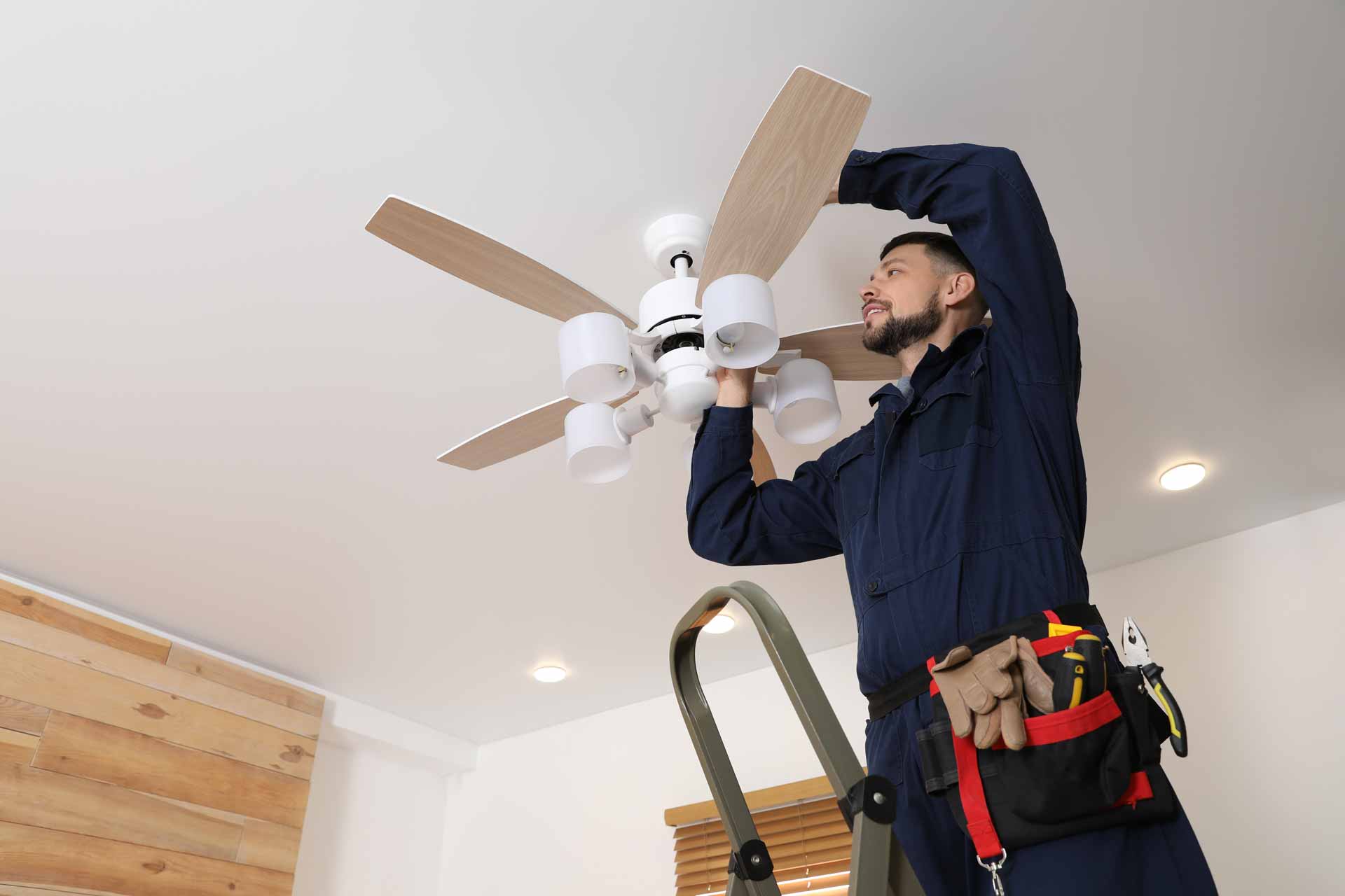 Electrician installing ceiling fan